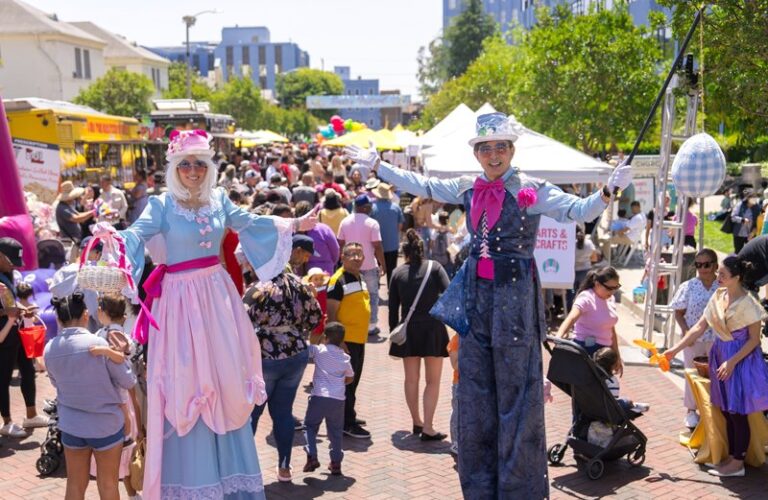 alice in wonderland themed stilt walkers welcomed everyone to the festival
